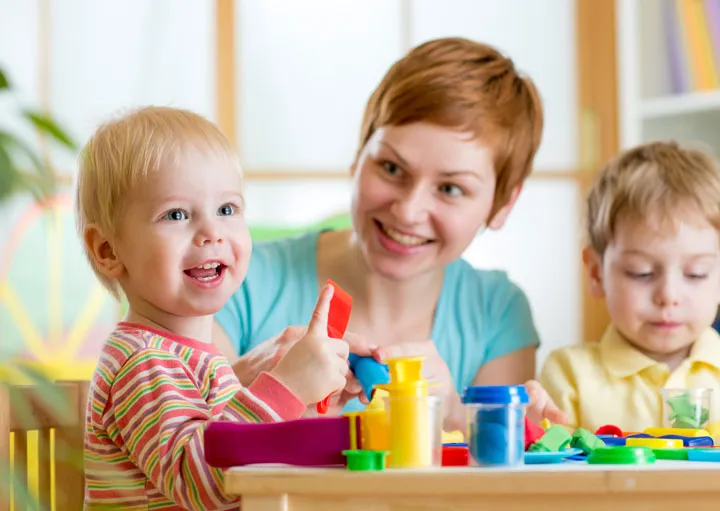 Teacher and children playing with playdoh at a childcare centre